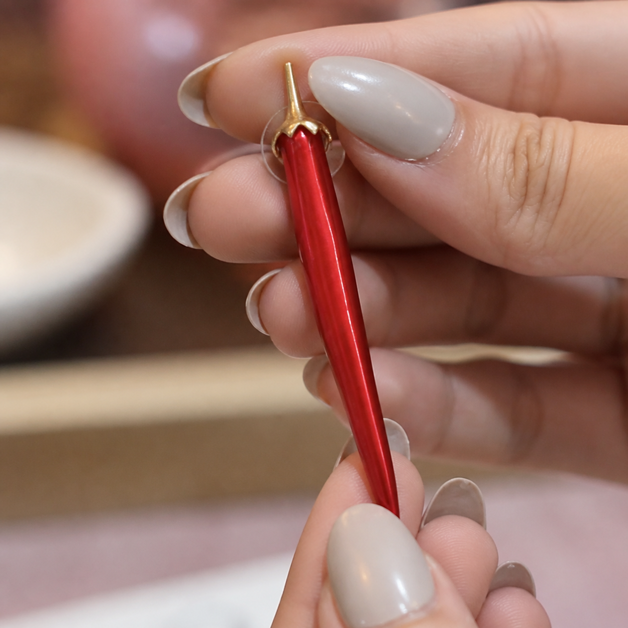 Crimson Curve Drop Earring held by hand