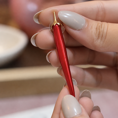 Crimson Curve Drop Earring held by hand